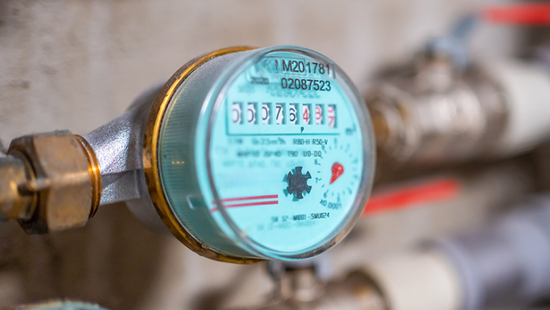 Close-up of a household water meter displaying usage readings.