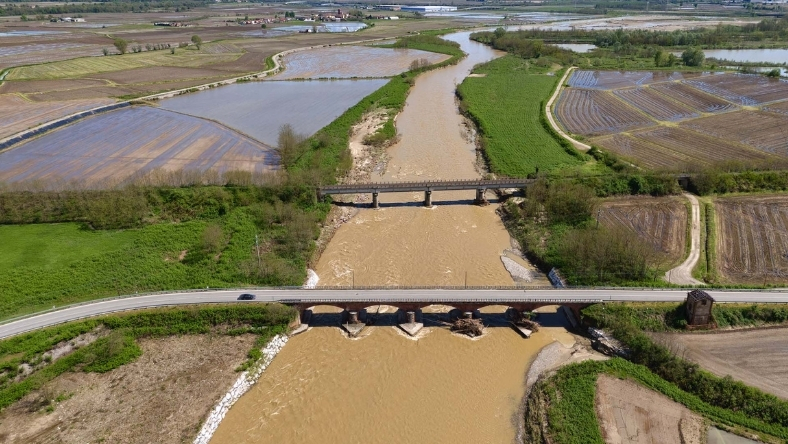 Aerial view of river running through farmland with road bridges