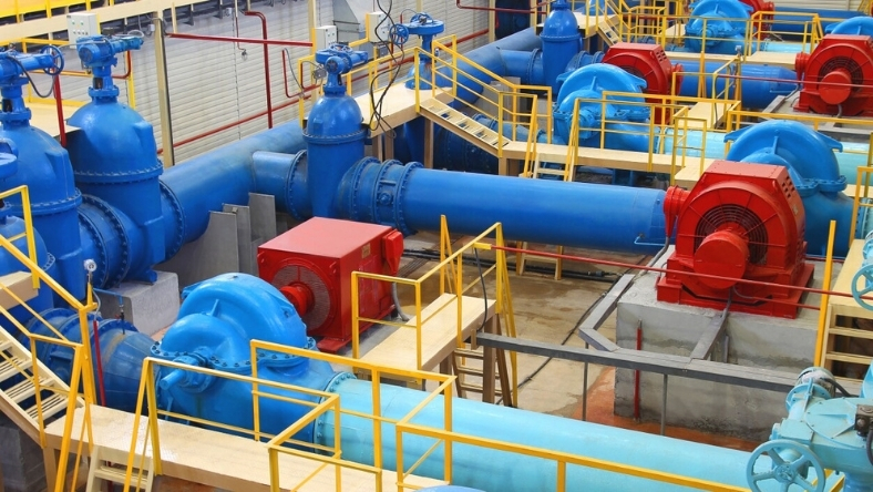 Industrial water utility facility with large blue pumps and pipeline system